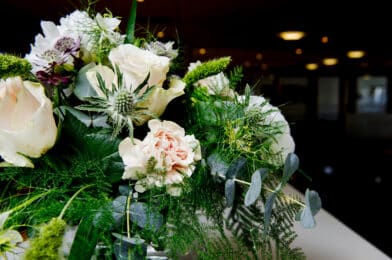 Blomsterbukett med lyserosa roser og mykje grønt. Til minnestund på Stord Hotell.