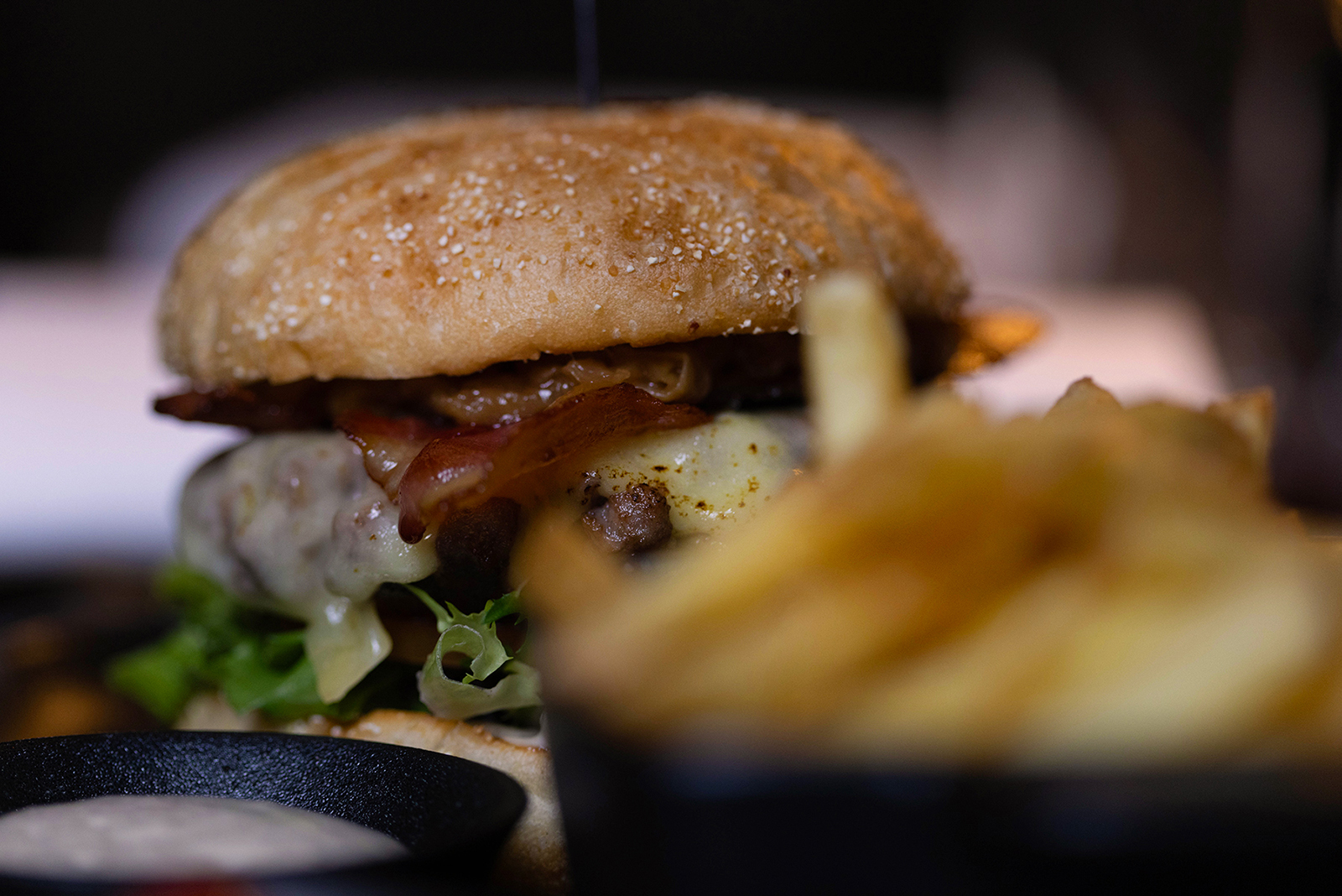 200 g angusburger med surdeigsbrød laga på øl, peppermajones, østavind-ost, salat, karamellisert løk, bacon og pommes frites